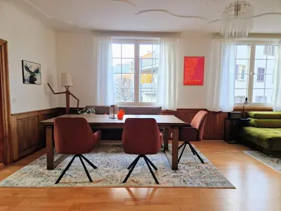 a living room with a dining room table and chairs at FEWOCASA Central Family Apartment Rorschach - Lake Constance - 15 min OLMA in Rorschach