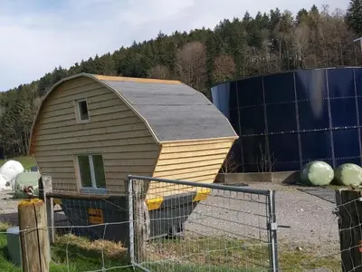 a smallshed sitting in a field next to a fence at Holiday Home Tiny Hause by Interhome in St. Gallen