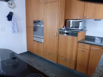 a kitchen with wooden cabinets and a microwave at Apartment Moderne FeWo by Interhome in Appenzell