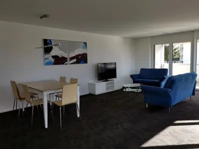 a living room with a table and a blue couch at Apartment HIRSCHEN by Interhome in Gossau