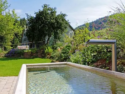 a swimming pool in the middle of a garden at Apartment Vordere Au by Interhome in Schwellbrunn