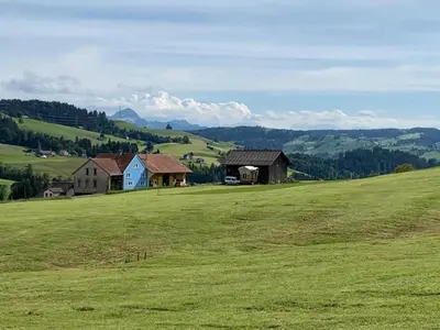a large green field with two houses on a hill at Apartment nirkwerk by Interhome in Schönengrund