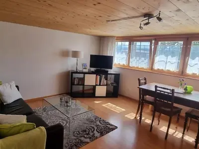 a living room with a table and a couch at Apartment Tiererlebnishof Windegg by Interhome in Urnäsch