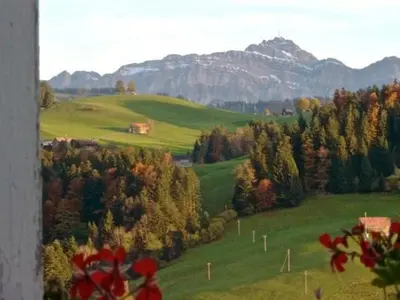 a green field with trees and mountains in the background at Apartment Hasenbüel by Interhome in Ricken