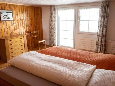 a bed in a room with a wooden wall at Holiday Home Hörli by Interhome in Sankt Peterzell