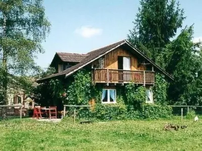 a wooden house with a balcony in a field at Holiday Home Alten-Hof by Interhome in Bischofszell