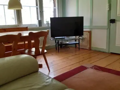 a living room with a television and a table with a chair at Holiday Home Frohheim by Interhome in Sankt Peterzell