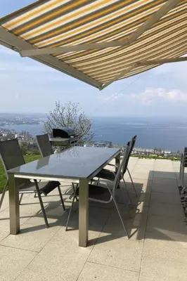 a table and chairs under a patio umbrella at Apartment Seehof by Interhome in Rorschacherberg