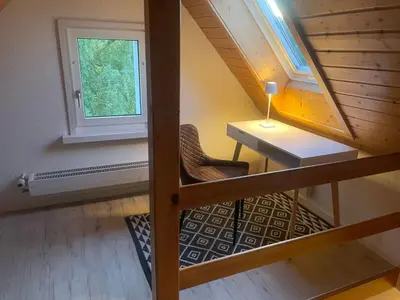 an attic room with a desk and a window at Apartment Wartheim by Interhome in Heiden