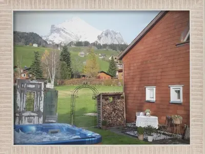 a house with a pool in the yard with a mountain at Apartment Studio Chic mit Whirlpool by Interhome in Wildhaus