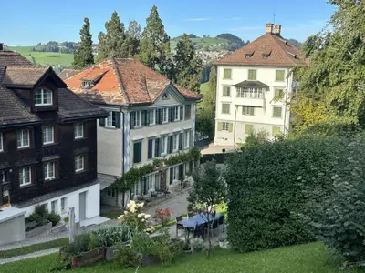 a group of houses in a yard with trees at Apartment Allegra Appenzell by Interhome in Trogen
