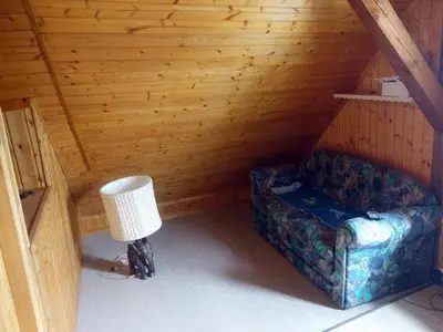 a room with a couch and a lamp in a cabin at Holiday Home das schiefe Haus by Interhome in Oberschan