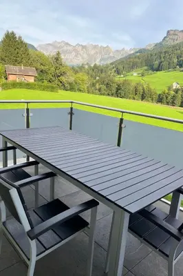 a picnic table and chairs on a balcony with a view at Apartment Panoramablick by Interhome in Nesslau