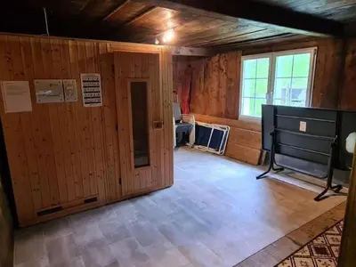 a room with wooden walls and a large window at Holiday Home Seuzach by Interhome in Nesslau