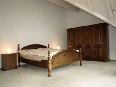 a bedroom with a wooden bed and a wooden cabinet at Apartment Zwingli's Ferienwohnung by Interhome in Nesslau