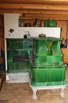 a green stove sitting in a room at Holiday Home Obere Laui by Interhome in Nesslau