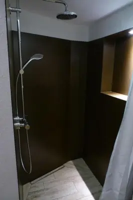 a shower in a bathroom with a black wall at Holiday Home Oberguet by Interhome in Unterwasser