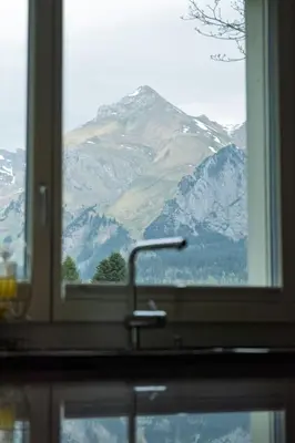 a window with a view of a snow covered mountain at Holiday Home Haus am Schwendisee by Interhome in Wildhaus
