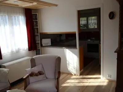 a living room with a chair and a kitchen at Apartment Chalet Lilian by Interhome in Unterwasser