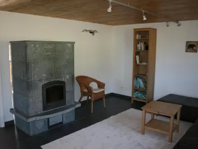 a living room with a fireplace and a chair at Apartment Bädli by Interhome in Wildhaus