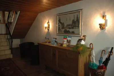 a room with a counter and a picture on the wall at Hotel Pension Im Dorf in Zuzwil