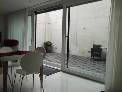 a room with a table and chairs and a glass door at Sunrise Apartment in Staad