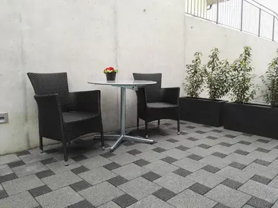 a table and four chairs on a tile floor at Sunrise Apartment in Staad