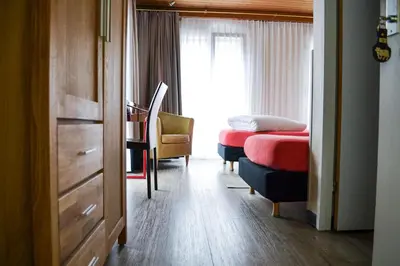 a bedroom with a bed and a desk and a window at Hotel Landhaus Säntis Herisau in Herisau