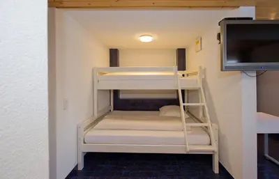 a bunk bed room with bunk beds and a tv at Landgasthof Werdenberg in Werdenberg
