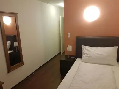 a bedroom with a bed and a large mirror at Hotel Bahnhof in Uzwil