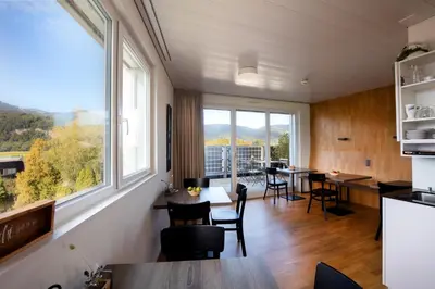 a dining room with large windows and tables and chairs at Hotel Restaurant Rhy in Oberriet
