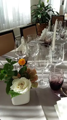 a table with wine glasses and flowers on it at Restaurant Blume in St. Gallen