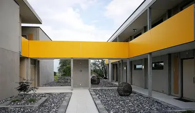 an external view of a building with a yellow ceiling at wohnMOTEL - Hinterforst in Altstätten