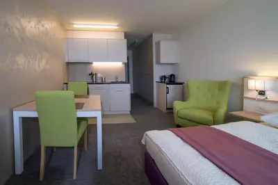 a hotel room with a bed and a table and chairs at wohnMOTEL - Hinterforst in Altstätten