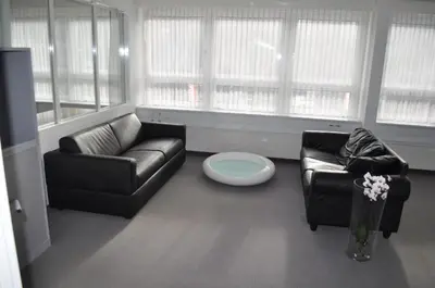 a living room with a leather couch and a chair at Loft AR in Bühler