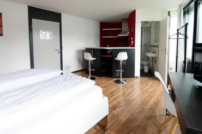 a bedroom with a large white bed and two chairs at Berger Zentrum in Berg