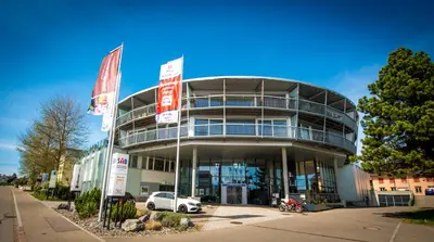 a large building with cars parked in front of it at Berger Zentrum in Berg