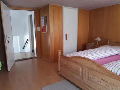 a bedroom with a bed and a mirror at Pizzeria-Pension Gambrinus in Walzenhausen