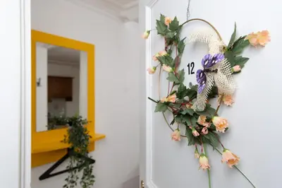 a wreath of flowers on a door with a clock at Gasthof Zur Traube in Roggwil