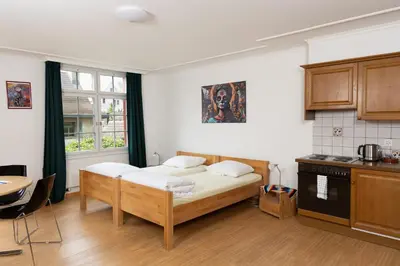 a bedroom with a bed and a table and a kitchen at Gasthof Zur Traube in Roggwil