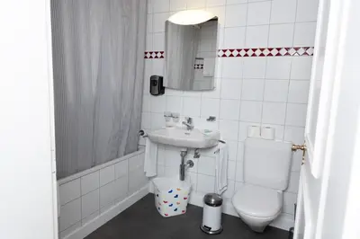 a white bathroom with a sink and a toilet at Gasthof Zur Traube in Roggwil