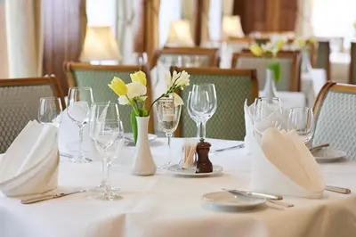 a table with wine glasses and flowers on it at Hotel & Spezialitätenrestaurant zur Linde in Teufen