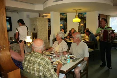 a group of people sitting at a table in a restaurant at Adler Hotel in Appenzell