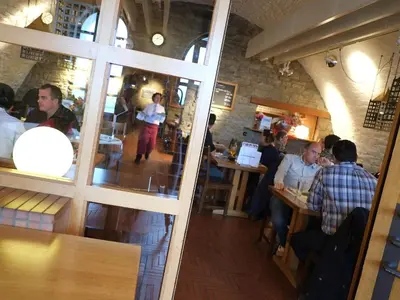 a group of people sitting at tables in a restaurant at Hotel Brauerei Frohsinn in Arbon