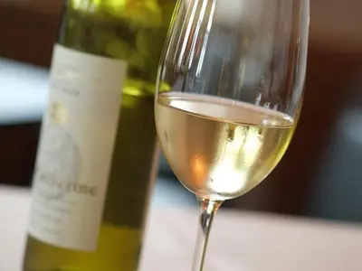 a glass of white wine next to a bottle of wine at Hotel Brauerei Frohsinn in Arbon