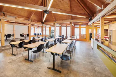 a dining room with wooden tables and chairs at Reka-Feriendorf Wildhaus in Wildhaus