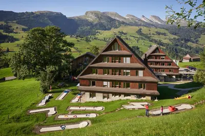 a rendering of a building on a hill with mountains at Reka-Feriendorf Wildhaus in Wildhaus