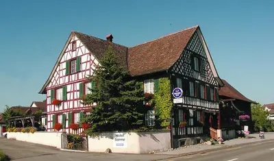 a black and white building with ivy on it at Hotel Garni Sonne in Landschlacht Gemeinde Münsterlingen