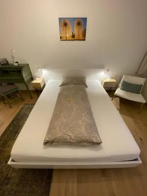 a white bed with a pillow on it in a room at Lakelodge Romanshorn in Romanshorn