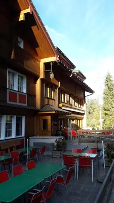 a building with tables and chairs in front of it at Waldgasthaus Lehmen in Weissbad